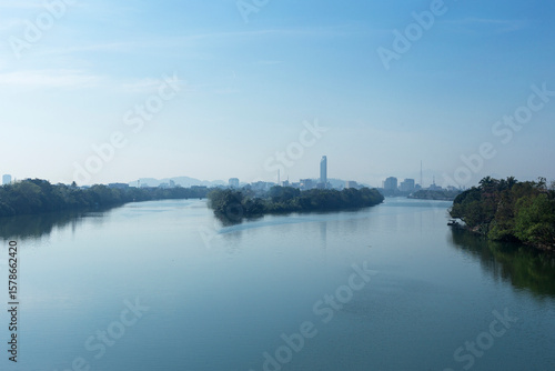 The Huong (Parfum) River in Hué, Vietnam, with the skyline in the background, surrounded by a peaceful and dreamlike atmosphere