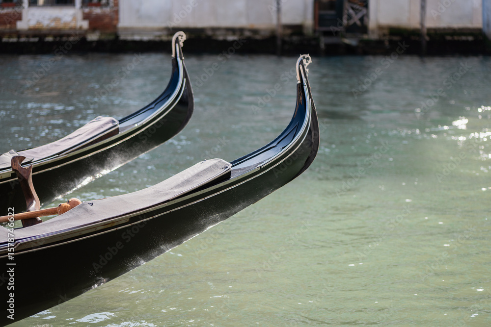 Gondola bows gracefully cut through the serene waters of a Venetian canal Gondola bows gracefully cut through the serene waters of a Venetian canal