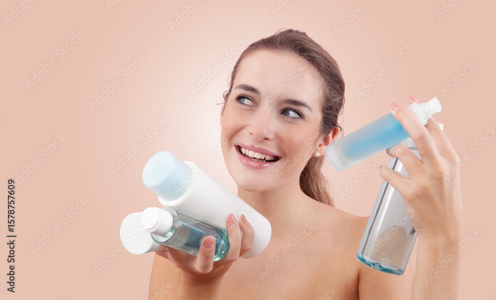 Smiling young woman holding various skincare bottles and bath products, including micellar water and shower gel. Daily beauty routine, clean skin and hygiene concept. Isolated on beige background Smiling young woman holding various skincare bottles and bath products, including micellar water and shower gel. Daily beauty routine, clean skin and hygiene concept. Isolated on beige background