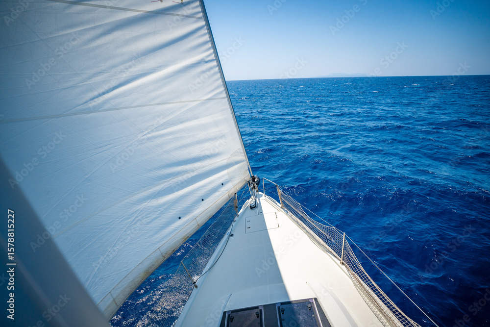 Obraz premium View from the mast down to the bow of a sailing yacht moving under full sails near Croatia. Freedom, adventure, yachting lifestyle and dynamic sea travel.