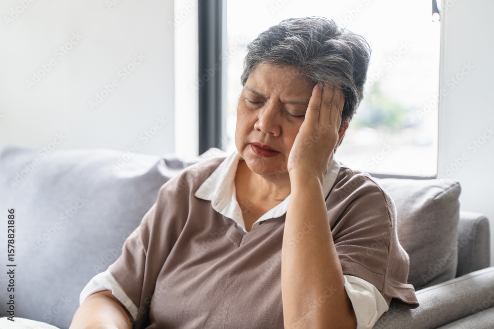 Elderly women feeling dizzy and headache sit on the sofa at home. Elderly women feeling dizzy and headache sit on the sofa at home.