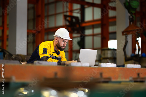 Laptop computer : blue collar working production line : Caucasian man engineer worker working control sheet metal roof tile roll forming machine at metal sheet profiling factory. Industrial production