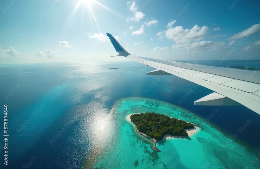 Obraz premium Airplane wing soars above tropical island in serene aerial view. Crystal clear blue water reflects sunlight creating vacation travel mood. Scenic picturesque landscape, summer holidays, paradise