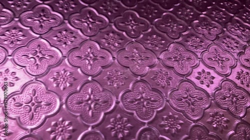 Pink frosted glass featuring an ornate, repeating pattern of floral and quatrefoil designs.