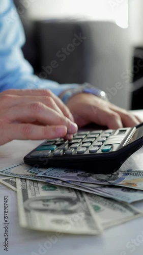 The hands of a man in a blue shirt count money using a calculator.
Calculation of income and interest.
Banker calculates salary or taxes on a calculator.
Using a calculator for accurate calculations
