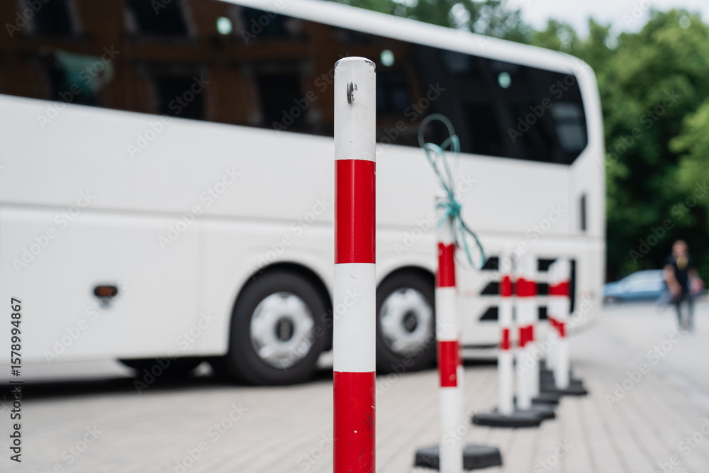 Fototapeta premium Orange traffic safety cone on urban paving near industrial building entrance for construction zone warning, hazard marking and pedestrian control