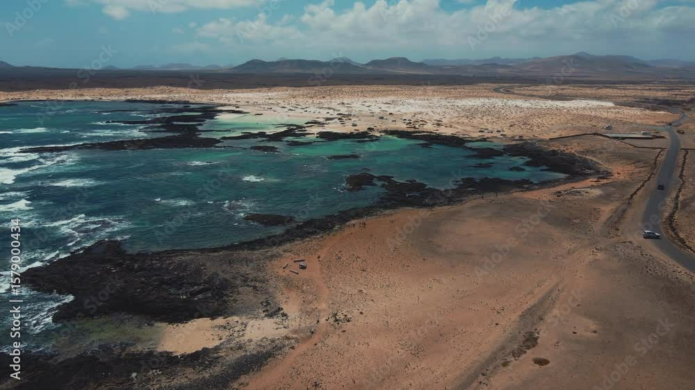 Turquoise waters gently caress the white sandy beaches of Fuerteventura, creating a breathtaking coastal panorama Turquoise waters gently caress the white sandy beaches of Fuerteventura, creating a breathtaking coastal panorama