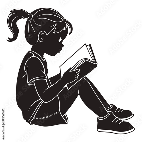 Silhouette of a young girl with a ponytail sitting cross legged and engrossed in reading an open book