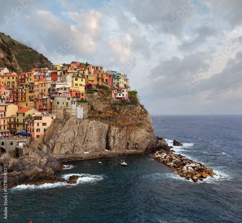 Beautiful summer Manarola - one of five famous villages of Cinque Terre National Park in Liguria, Italy, suspended between Ligurian sea and land on sheer cliffs. People and signs unrecognizable.