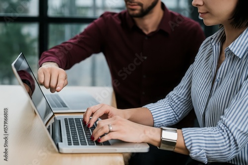 Business colleagues collaborate using a laptop in a modern office, showcasing teamwork, professionalism, and a focus on technology, creating a productive environment.