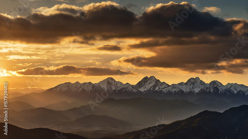 Sunset view over mountain ridges with dramatic sky and golden sunlight touching the peaks. Captured in natural lighting, wide panoramic format, high-resolution. No text, no people. Ideal for travel  