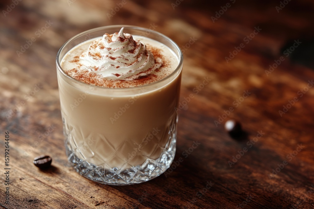 Creamy coffee beverage topped with whipped cream and cinnamon, served in a rocks glass. Creamy coffee beverage topped with whipped cream and cinnamon, served in a rocks glass.