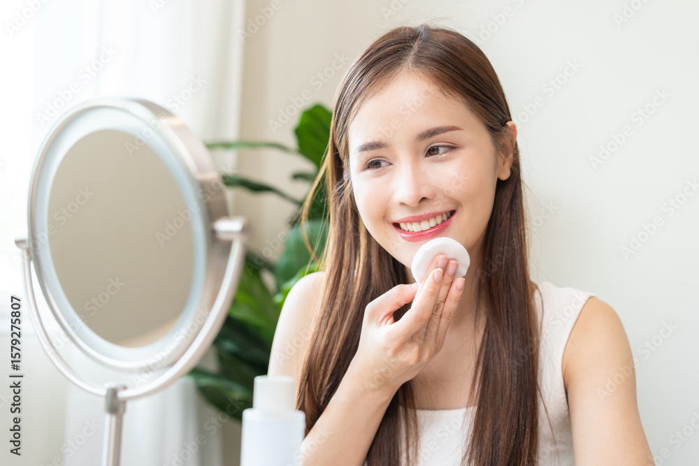 Remove makeup, attractive asian young woman, girl looking into mirror, hand holding cotton pad, apply facial wipe cleaning on her skin face, essence or lotion for treatment, skin care routine at home. Remove makeup, attractive asian young woman, girl looking into mirror, hand holding cotton pad, apply facial wipe cleaning on her skin face, essence or lotion for treatment, skin care routine at home.
