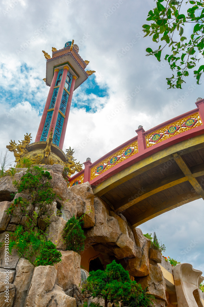 Fototapeta premium Ornate asian architectural structure with vibrant details and cloudy sky background