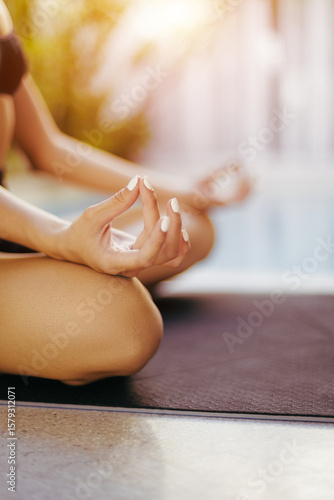 Wallpaper Mural Young caucasian female practicing yoga meditation by a pool Torontodigital.ca