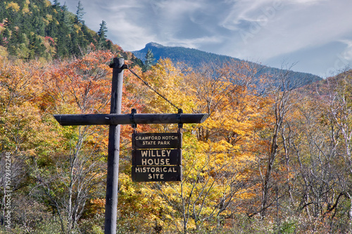View of colorful fall foliage and distant summit of Mount Crawford from Crawford Notch State Park in New Hampshire's scenic White Mountains.