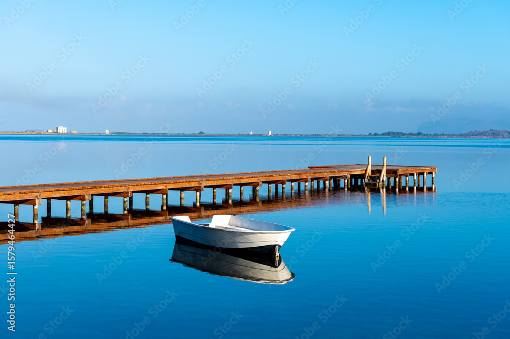 Obraz premium Morning stillness and mirror-quiet water at Stagnone of Marsala, lagoon and nature reserve near Marsala, Sicily, Italy, fisherman's boats