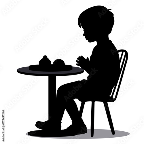 Silhouette of boy sitting at table with desserts in cafe  