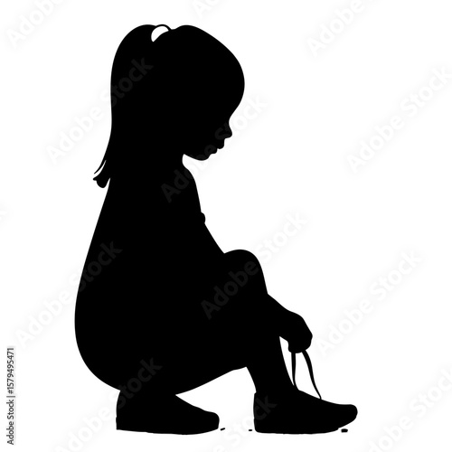 Silhouette of girl tying shoelaces while sitting on the ground  