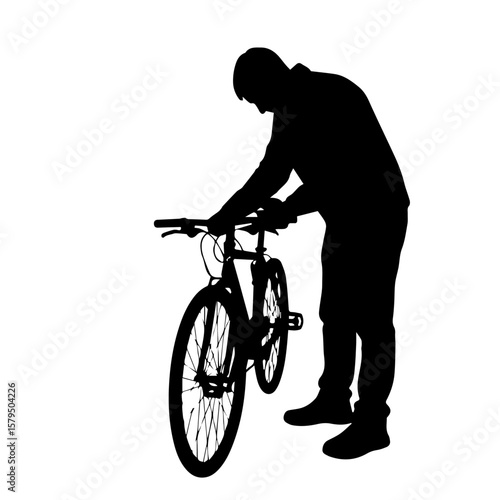Man adjusting bicycle while standing in silhouette  