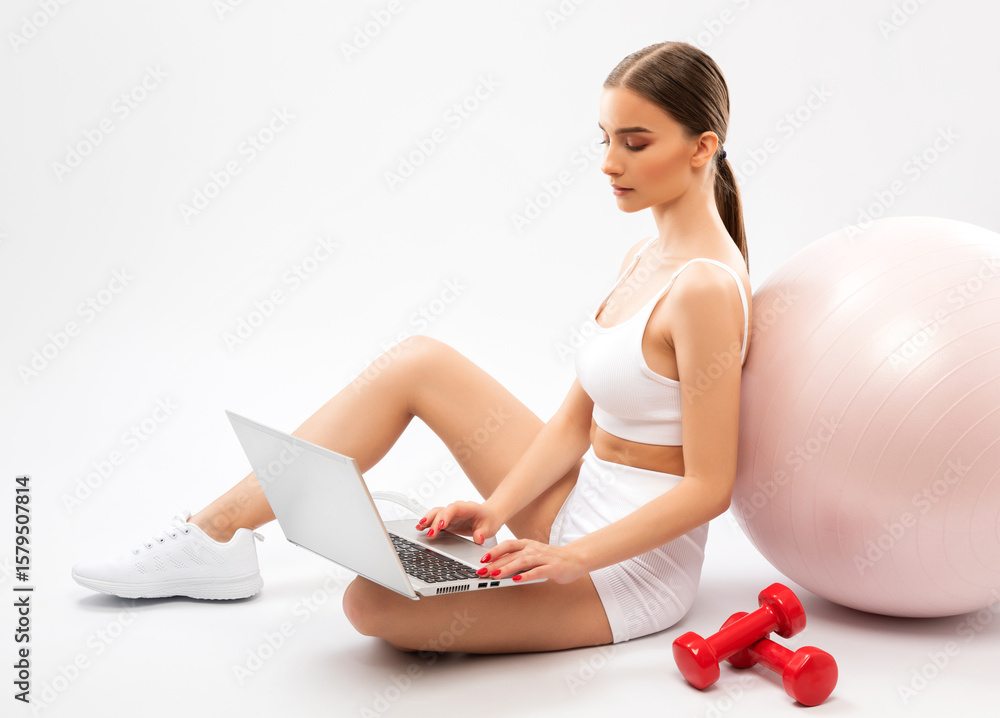 Naklejka premium Slender dark-skinned female blogger in a white tracksuit against a white background. Healthy lifestyle, sports and diet.