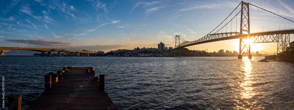 Fototapeta premium panorâmica por do sol em Florianópolis Santa Catarina Brasil e a ponte Hercílio Luz Florianopolis e esquerda parte do pier 