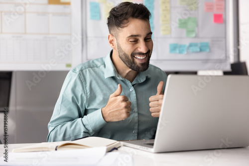 Photography Smiling Latino man participate video call with colleague, showing thumbs-up as g