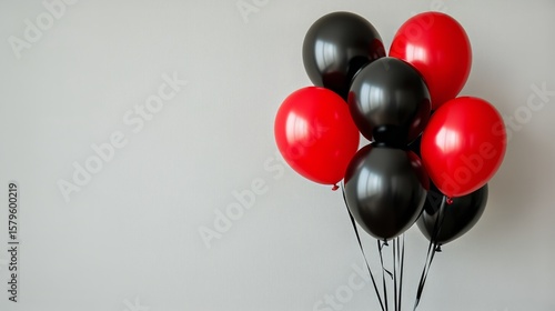 Colorful Black and Red Balloons Arranged Against a Light Background for Celeb...