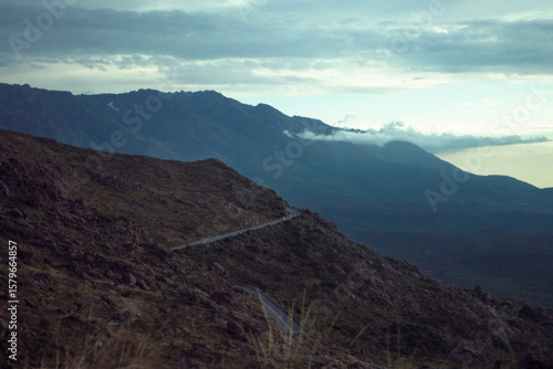 a car crossing a road in the mountains at dawn