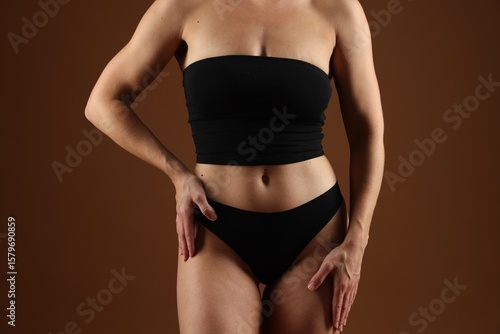 Fit woman with perfect body on brown background, closeup © New Africa