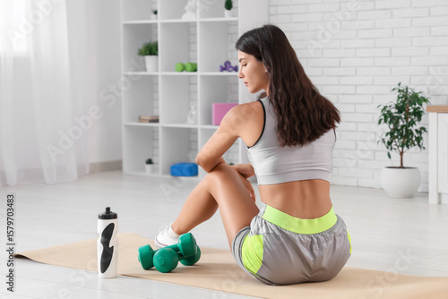 Young woman sitting on yoga...