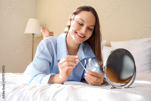 Young woman with cotton bud...