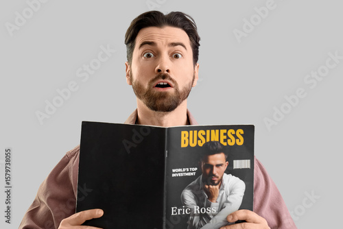 Shocked young man reading b...