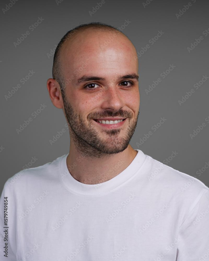 Fototapeta premium Young man with a variety of emotions, wearing a white t-shirt standing against a green background. Studio shot with copy space.