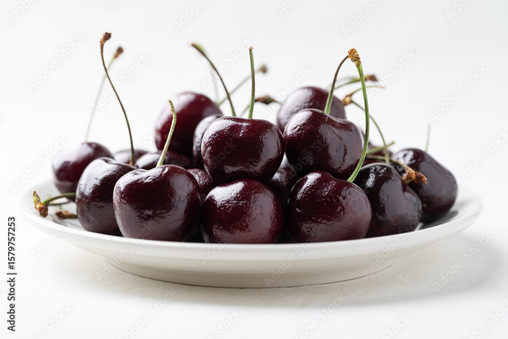 Fresh ripe cherries fruit on white plate with clean white background, Healthy eating and seasonal Fresh ripe cherries fruit on white plate with clean white background, Healthy eating and seasonal