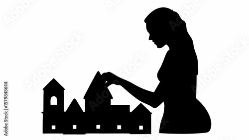Silhouette of a woman building a miniature town with houses and buildings in a creative and artistic way