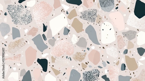 A close-up of a terrazzo surface featuring a variety of colorful stone fragments in pink, gray, beige, and black embedded in a light background.
