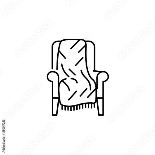 A cozy armchair with a blanket with a minimalist line drawing.