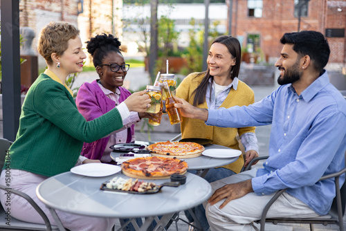 Photography Group of friends enjoying a meal together outdoors, clinking glasses in a celebratory toast