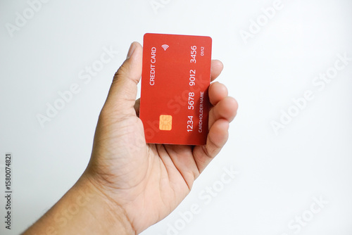 Close up of hand with red credit card isolated on white background. Shopping, finance and people concept
