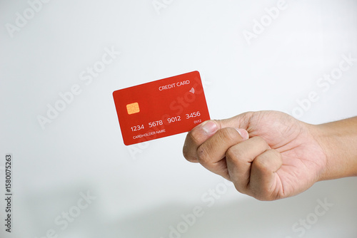 Close up of hand with red credit card isolated on white background. Shopping, finance and people concept