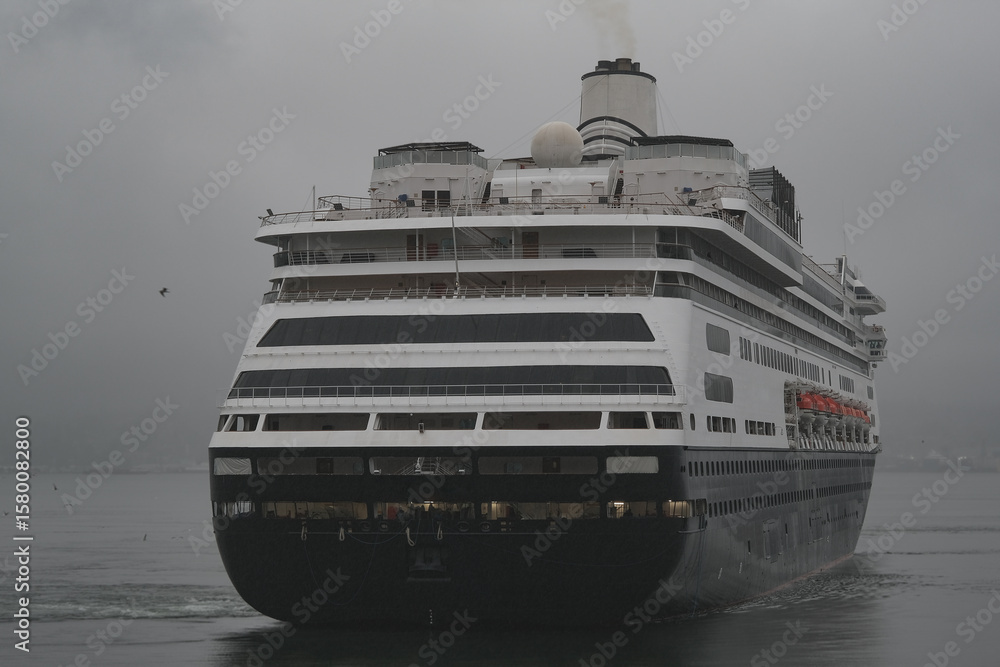 Obraz premium Classic cruiseship cruise ship liner Zaandam arrival into Vancouver, Canada port on grey foggy misty morning from Alaska cruise British Columbia rain day