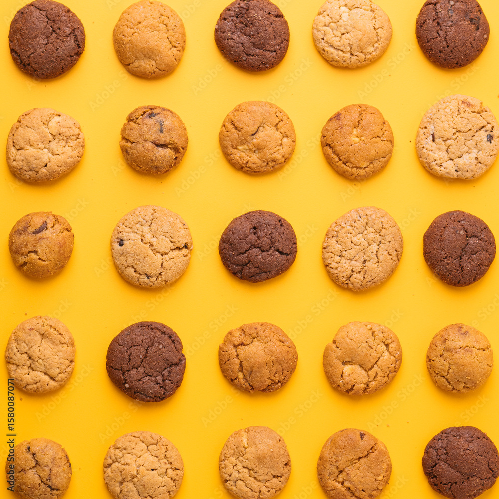 Pattern of Assorted Cookies on Yellow Background, Top View of Chocolate and Vanilla Cookies Arranged in Rows, Colorful Cookie Grid on Bright Yellow Backdrop, Cookies in Perfect Order – Minimalist Foo Pattern of Assorted Cookies on Yellow Background, Top View of Chocolate and Vanilla Cookies Arranged in Rows, Colorful Cookie Grid on Bright Yellow Backdrop, Cookies in Perfect Order – Minimalist Foo