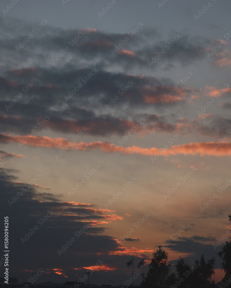 Fototapeta premium Dramatic Sunset Sky with Layered Clouds and Fading Light at Dusk