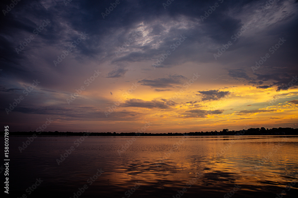 Obraz premium warm orange and yellow sunset over the lake