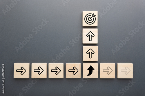 Tableau sur toile Wooden blocks with arrow icons and target symbol show concept of changing direct