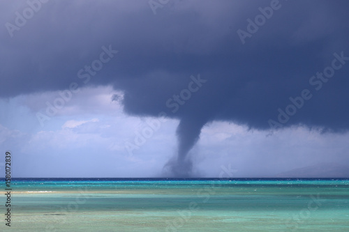 Photos Waterspout (whirlwind, water tornado, storm funnel) Over Ocean Under Dark Storm