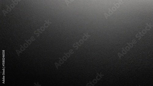 Black matte paper surface with subtle grain texture creates smooth and elegant background, perfect for design projects or artistic presentations with refined feel
