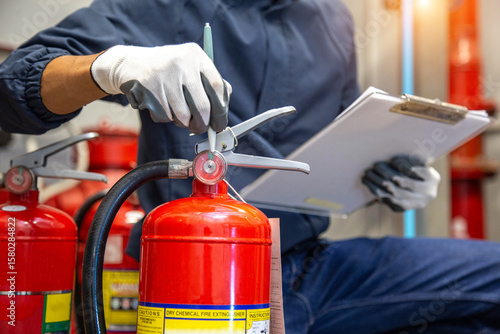 Engineer are checking and inspection a fire extinguishers tank in the fire control room for safety training and fire prevention.