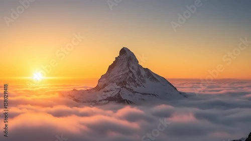 Mountain peak above clouds at sunrise